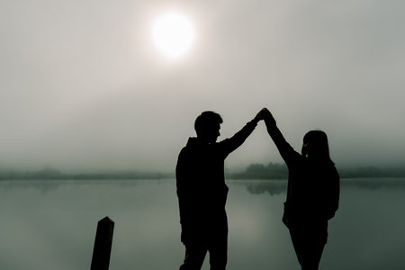 Image of Siluette, a lovely Asian couple, bright and bright, standing in the tourist area. Along the...