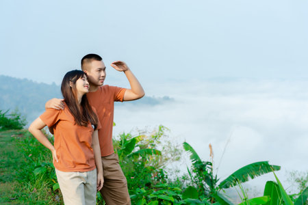 Portrait of a young Asian couple wearing the same brown shirt showing their love in a beautiful...