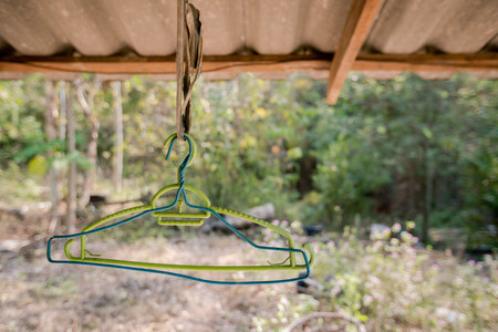 Old blue and green hangers hanging under the roof of the house.の写真素材