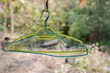 Old blue and green hangers hanging under the roof of the house.の写真素材