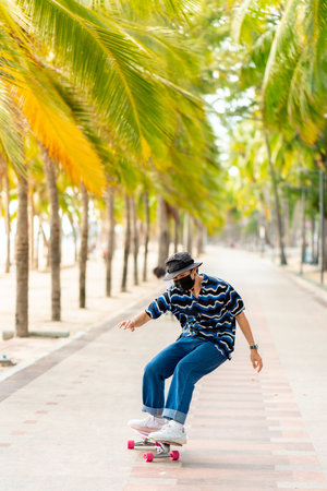 A young Asian man in a striped shirt and trousers is figure skating on a beach filled with coconut palms, during a clear sky time. and no people beach , surf skating, Bangsaen, Thailandの写真素材