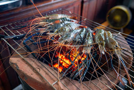 Big fresh prawns laying on the grill, being burned to turn orange, are a very tasty part of Thai food.の写真素材