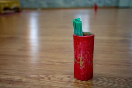 Close Up Old red siemsee with green siamese stalks placed on the ground in a temple for tourists to try their luck on the day of their wishes.の写真素材