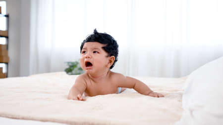 A four-month-old newborn boy just woke up from his sleep and was crying because he couldn't find his mother. Concept Happy Familyの写真素材