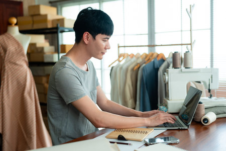 Sitting and typing, chatting about cutting dresses, designing dresses that customers order, with...