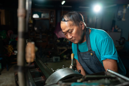 Portrait of Asian senior man working as a steel lathe is preparing work and equipment to turn steel...