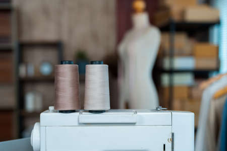 Close Up Two rolls of sewing thread placed on a sewing machine in the designer's workshop for sale online.の写真素材