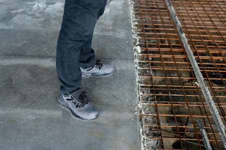 Close up Men's feet wearing leather shoes, which are safety shoes with steel inside to prevent injuries in construction site work.の写真素材