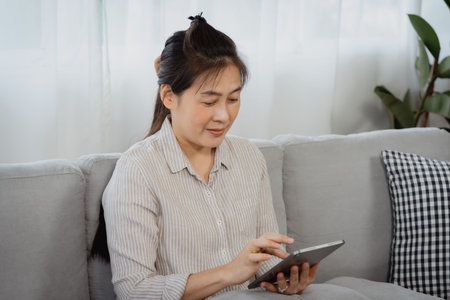 Asian single mom, shopping online, through the laptop he held in hand, He's so focused on the online...