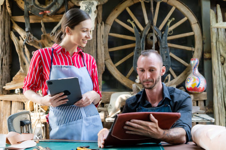 Close-up face handmade leather craftsmen, women men these two are discussing issue leather production, consult each other before working on each piece get best work for customer.の写真素材