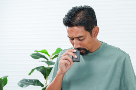Close-up hands Asian man still wore pajamas in morning, standing in kitchen picking up bag coffee...