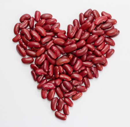 Red kidney beans on a white background. Red beans in the form of heart on a white background...