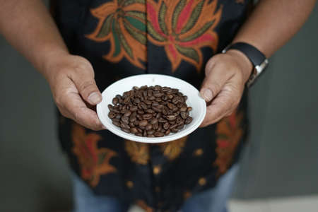 a plate Arabica  coffee roasted beans that are ready to be grindedの写真素材