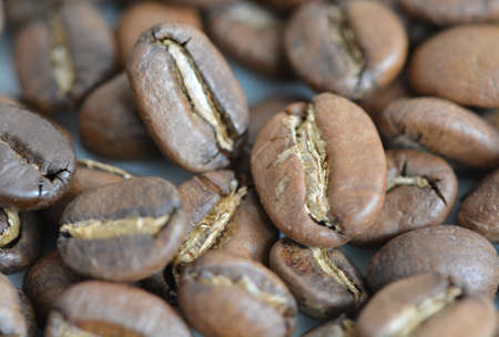Close up view of roasted arabica coffee beans on a blurred coffee backgroundの写真素材