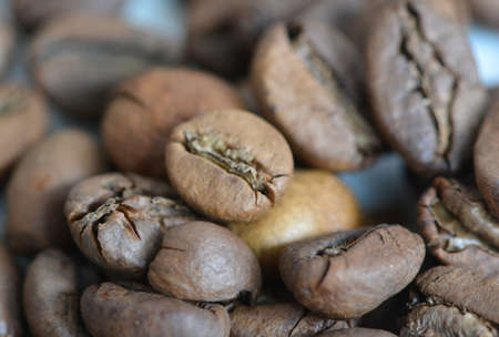 Close-up view of roasted robusta coffee beans with blurred coffee backgroundの写真素材