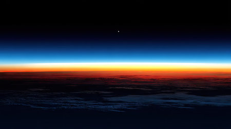 Aerial view of Earth's sunrise or sunset as seen from space. The image showcases the transition from dark space to a vibrant band of colors across the horizon, indicating the sunrise or sunset on the planet's surface below.  The clouds and dark spaces create a contrast that emphasizes the scale and beauty of the planet.の素材
