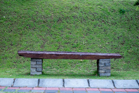 wooden chair in a park with green grass background,
