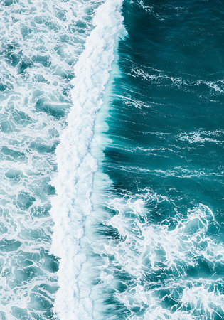 Aerial view of the sea waves with white foam on blue backgroundの素材