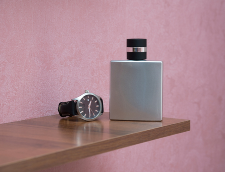 Gentleman concept. Clock and  bottle of perfume on the shelfの写真素材