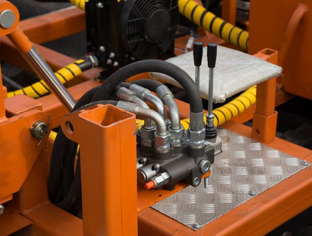 Hydraulic tubes, fittings and levers on control panel of lifting mechanism