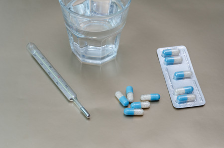 Water glass and medicaments on gray backgroundの写真素材