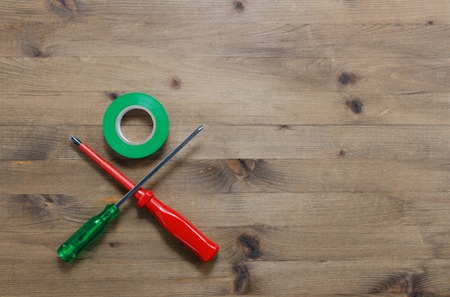 colored screwdrivers with duct tape on wooden tableの写真素材
