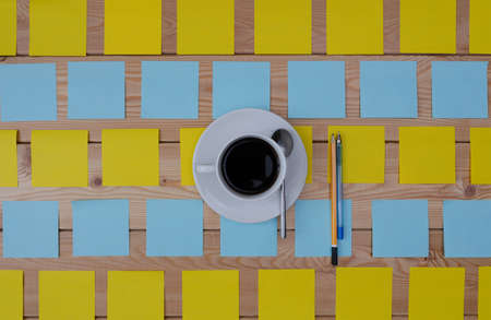 colored stickers cup of coffee and pen laying on the board.