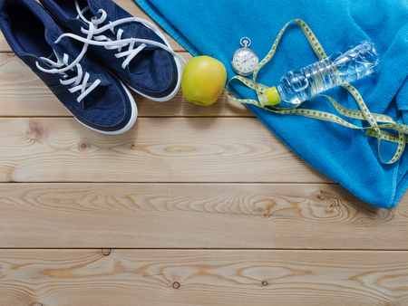 Fitness concept with sneakers notebook  stopwatch apples towel and measure tapeの写真素材