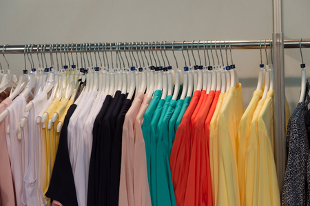Multicolor women clothes on hangers in the shop. Selective focus.の写真素材