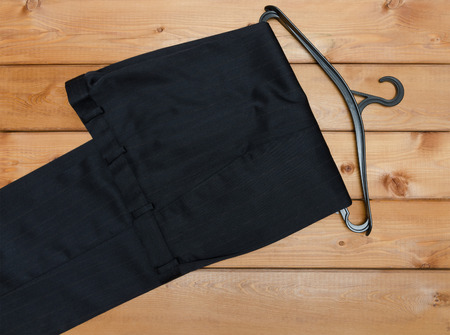 pants and hanger on wooden table backgroundの写真素材