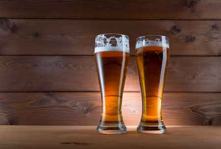 Two glasses of golden beer on wooden background の写真素材