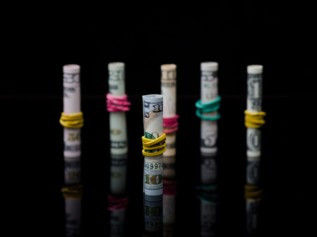 Dollar banknotes rolls on black background with reflection. Business conceptの写真素材