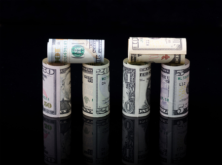 Dollar banknotes rolls on black background with reflection. Business concept.の写真素材