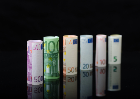 European paper money in rolls, on black background.の写真素材