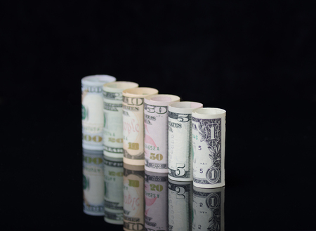 US dollars banknotes rolls on black background with reflection. Creative business and financial concept with usa dollar banknotes.の写真素材