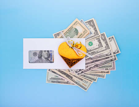Financial business success, bonuses in salary and high revenue and profit rate concept with gift box over dollar bills pile on blue background, top angle viewの写真素材