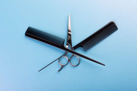 Professional tools for hairdresser on blue background: hair combs and haircutting scissors. Hairdresser equipment for hairstyle in salon or barbershop conceptの写真素材