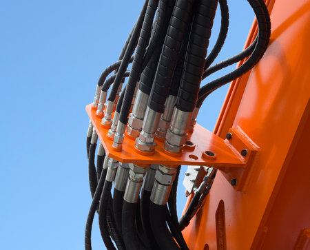 Detail of hydraulic bulldozer piston excavator arm against blue skyの写真素材