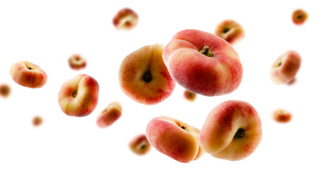 Excellent retouched flat peaches fly and levitate in space. selective focus. isolated on whiteの写真素材