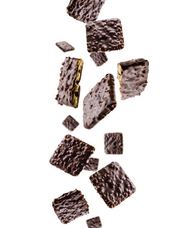 Cookies coated with chocolate and nuts fall in space. Surround light from behind. Isolated on white.の写真素材