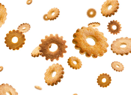 Cookies shaped like flower sprinkled with sugar fly and levitate in space. Volumetric back light. Isolated on whiteの写真素材