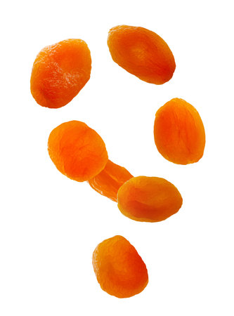 Dried apricots fly in space forming an abstract figure. Volumetric back light, due to which dried apricots glow from inside. Isolated on whiteの写真素材