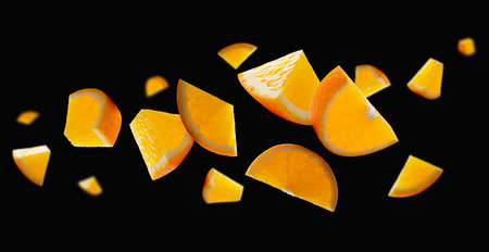 Orange slices of different shapes form an abstract figure in space. Isolated on black