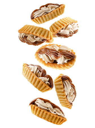 Two types of cream filled tartlets falling in space. Isolated on whiteの写真素材