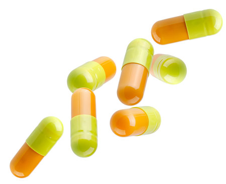 Double color tablets capsules fly in space forming a chain shape. Isolated on whiteの写真素材