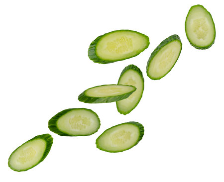 Cucumber slices in oval serving form for table setting fly in space forming an unusual figure. Isolated on whiteの写真素材