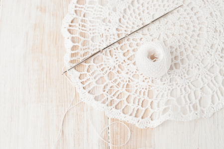 knitted cloth, a ball of white thread, hook vasconia on white wooden backgroundの写真素材