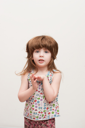 girl in a wig, hands folded on his chest, on a white backgroundの写真素材