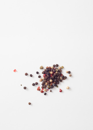 Handful of red, white, black peppercorns on a white background. Place for the text.の写真素材