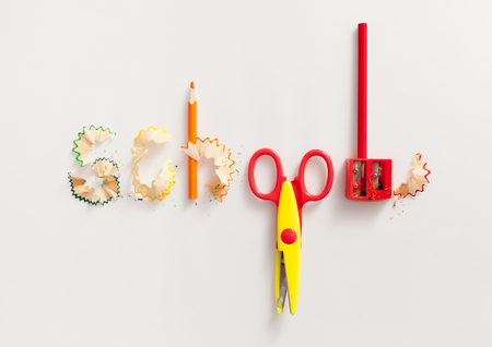 The inscription school of colored pencils, sharpeners and scissors